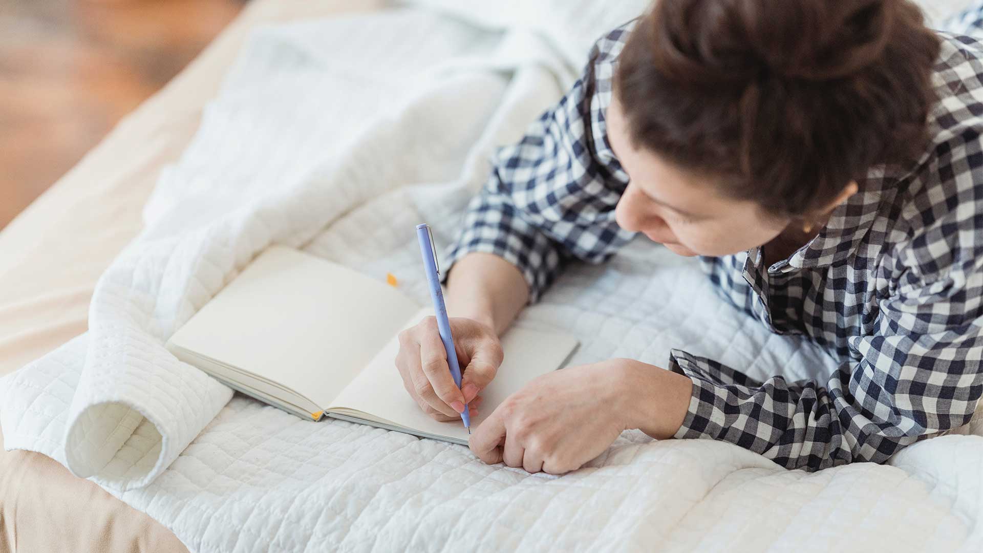 A woman journalling on her bed